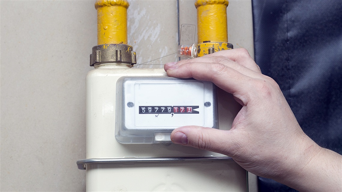 Person's hand holding a gas meter readout