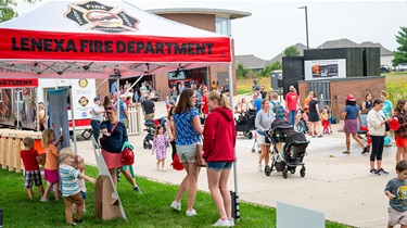 Crowd of people milling outside near Lenexa Fire Department tent