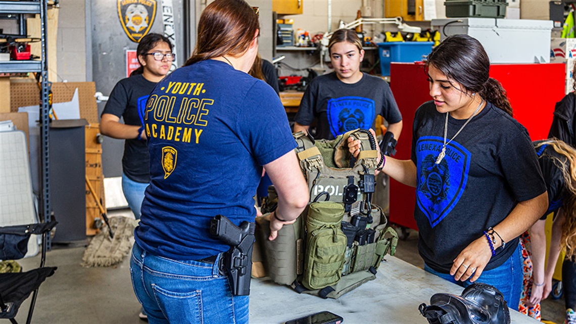 Teens with officer loading a safety vest