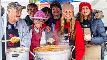 Chili Challenge team poses with giant pot of chili