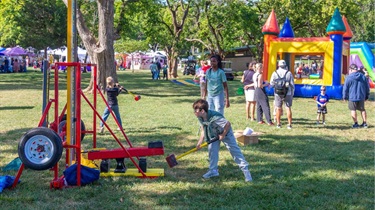 kids playing yard games and waiting in line for bounce houses