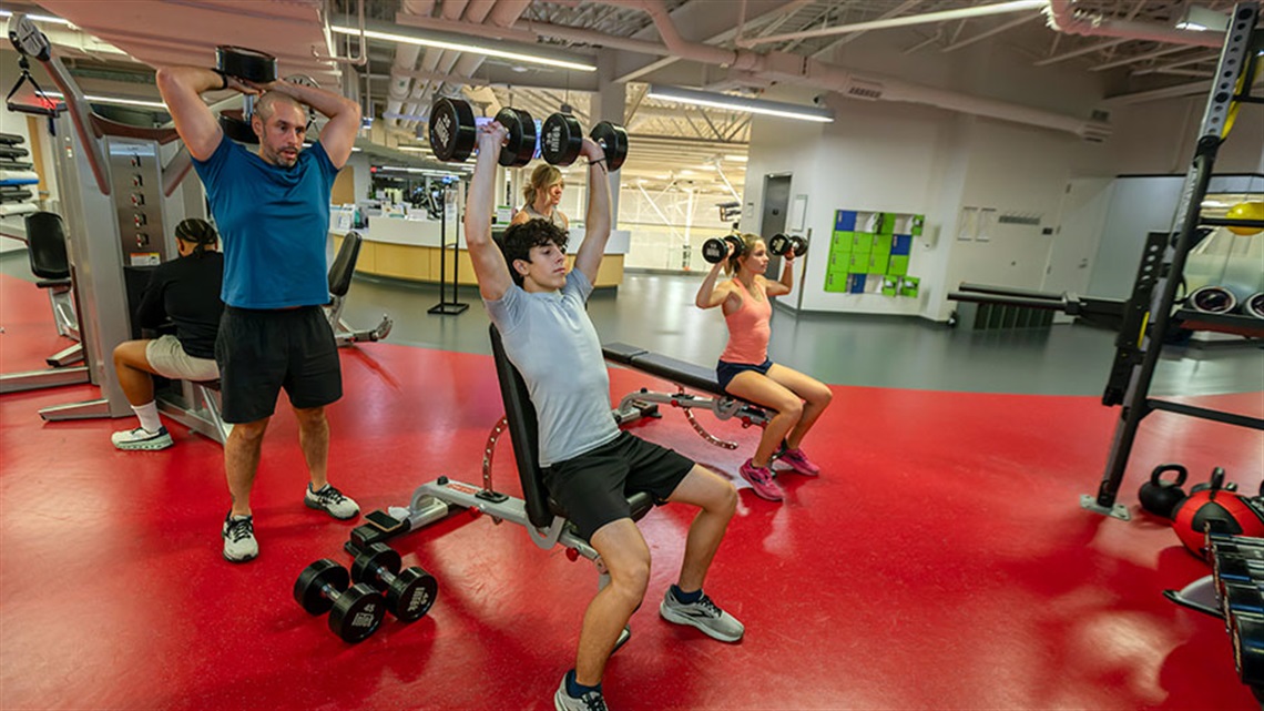 parents and teenage children lifting weights