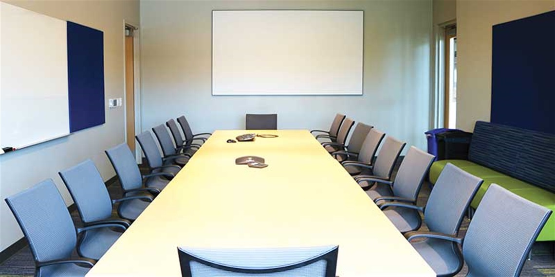 conference room table surrounded by chairs