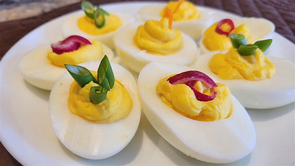 Deviled eggs with garnishes on a plate